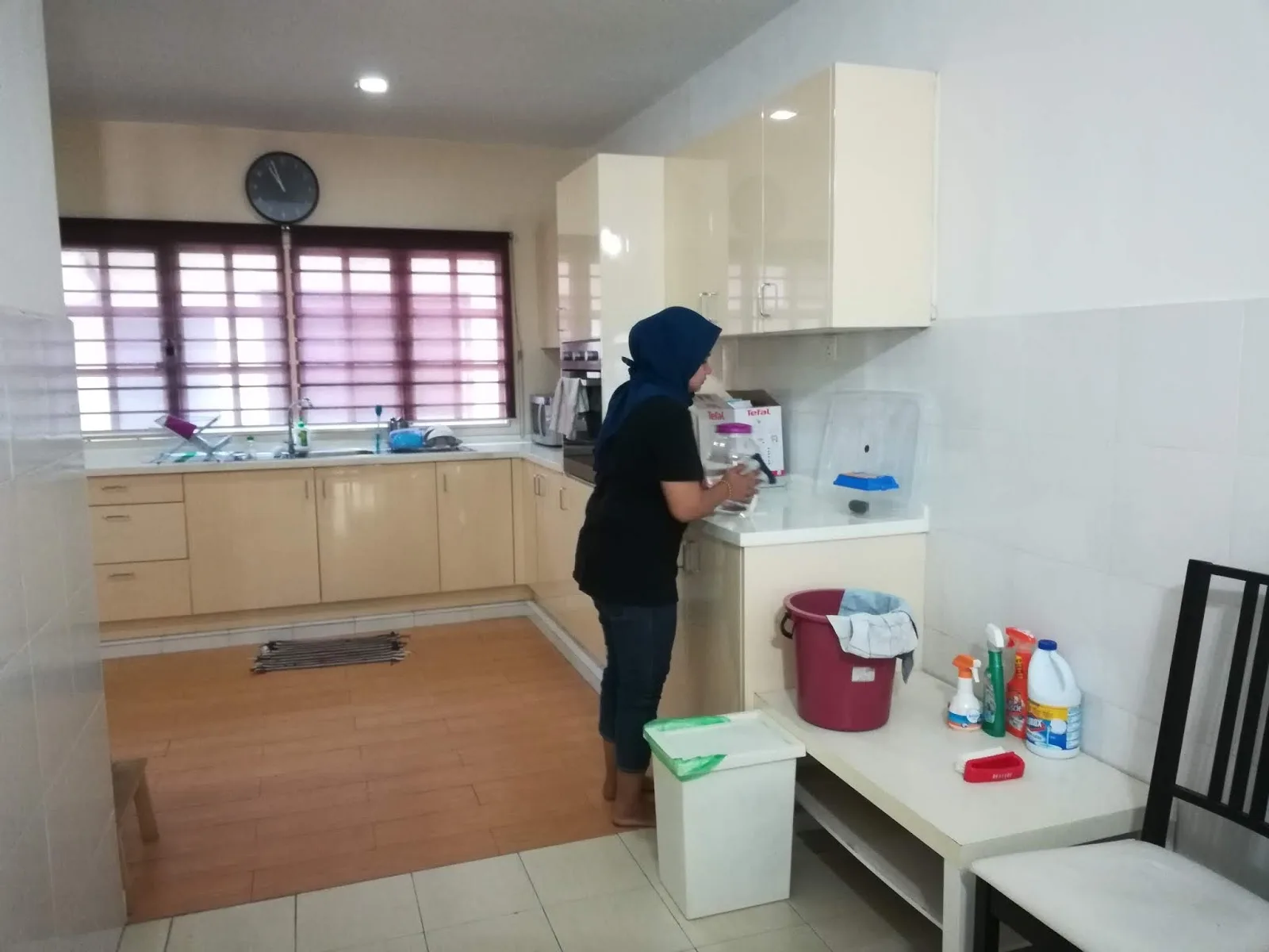 Tukang cuci membersihkan kaunter dapur semasa pembersihan rumah