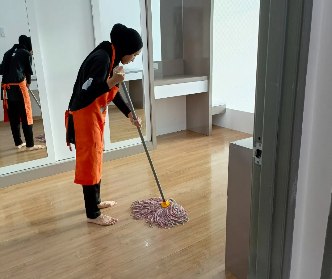 Cleaner mopping a wooden floor during move in move out cleaning